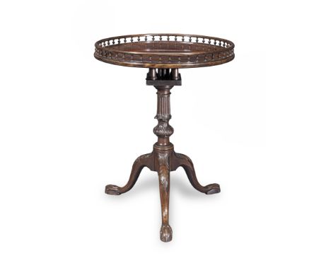 A George III mahogany tripod tableThe circular tilt-top with a baluster galleried edge, above a bird cage mechanism, on a flu