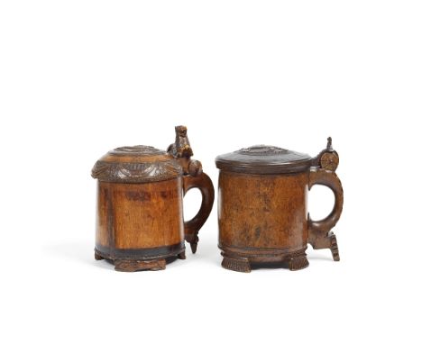Two 18th century Norwegian carved and turned birch-wood tankardsboth with domed covers, each carved with a lion rampant in re