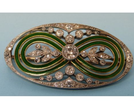 An Edwardian platinum and gold oval brooch with two bands of enamel in a figure of eight design, the centre set with a diamon