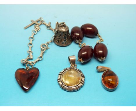 A sterling silver charm bracelet with a silver cross, silver bell charm and a heart shaped amber charm, a pair of cherry ambe