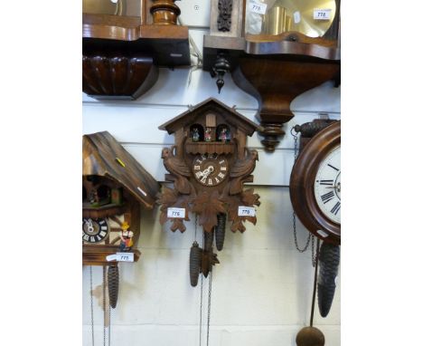 A circa 1960 three train cuckoo clock with dancing figures and carved bird decoration