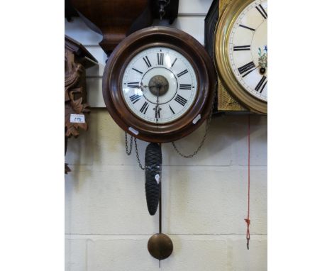 A weight driven wall clock with Black Forest movement, pine cone weight and alarm mechanism
