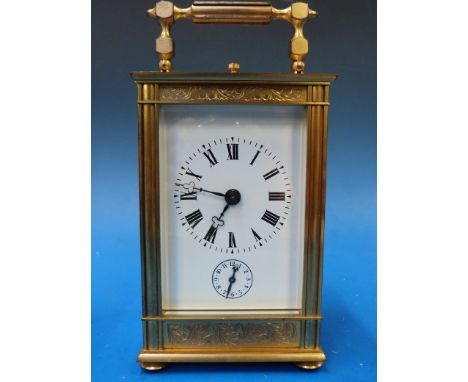 A c1900 French carriage clock with striking movement marked "France", gilt case with chased decoration, white enamel dial wit