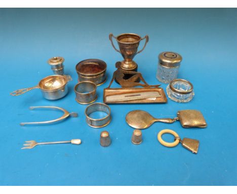 An hallmarked silver trophy cup, napkin rings, tea strainer, vesta case, novelty sugar tongs formed as a wishbone, a hallmark