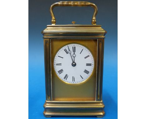 A gilt cased repeater carriage clock with white enamel dial, striking on a gong