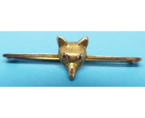 A yellow metal brooch marked 9ct modelled as a fox head with ruby eyes 