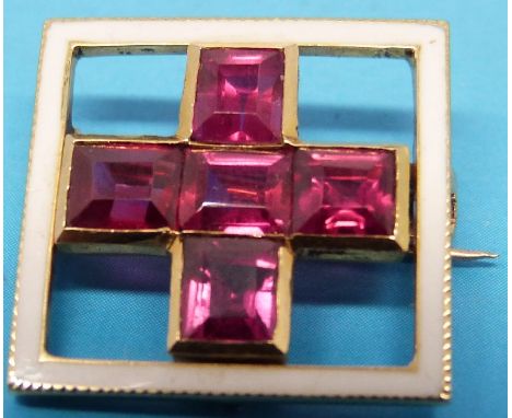 A square yellow metal brooch set with five rubies surrounded by a square of white enamel possibly depicting the Red Cross sym