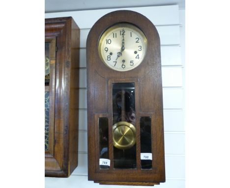 An arched top oak cased wall clock with three train movement by Enfield 