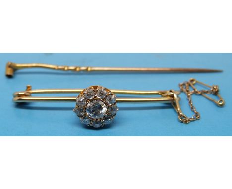 A yellow metal bar brooch set with 10 diamonds in a flower cluster, the centre diamond measuring approx 0.35ct. The flower cl