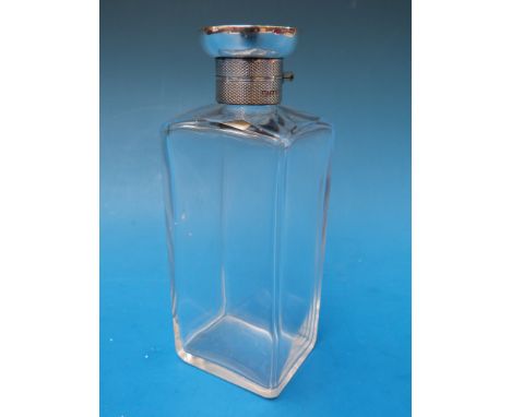 A square cut glass hallmarked silver mounted dressing table bottle with engine turned bayonet top. London 1925, height 14.5cm