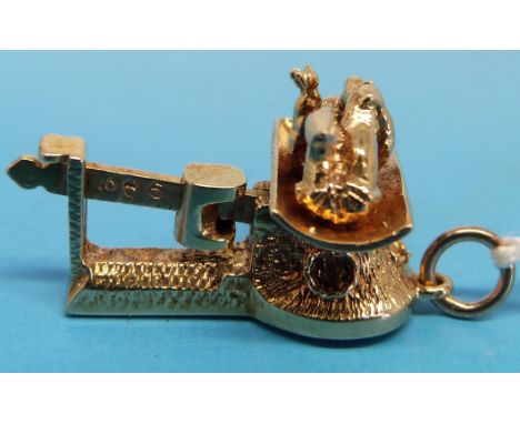 A 9ct gold charm in the form of a baby on scales with articulated mechanism and slide weight, London, marked 375 (6.6g)