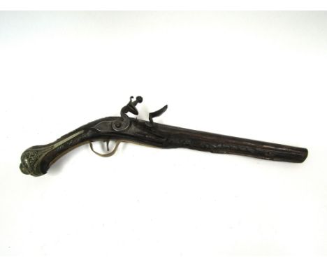 An 18th Century flintlock pistol, the lock plate and hammer engraved with scrolled work joining a rounded barrel, the walnut 