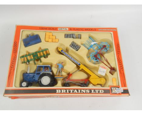 A Britains Limited boxed farm tractor and implements set, to include Ford tractor elevator, farmer, bales, milk churns etc., 