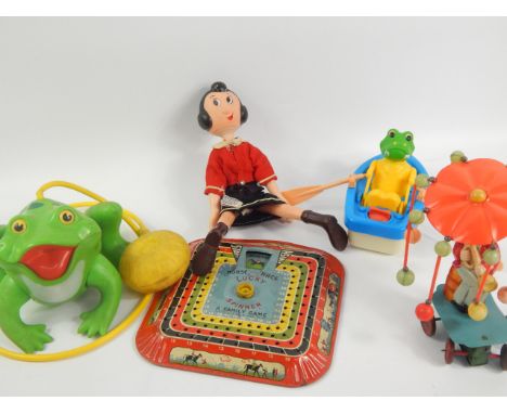 A collection of tin plate and other toys, including a Lucky Spinner horse race game, Jumping Frog, Olive Oil doll and a clock