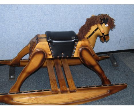 A pine rocking horse, with a leather seat, 96cm long.