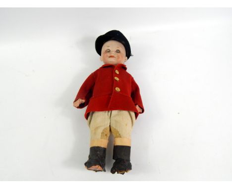 An early 20thC Armand Marseille bisque headed hunting doll, with blue sleep eyes and articulated limbs, dressed in a red hunt