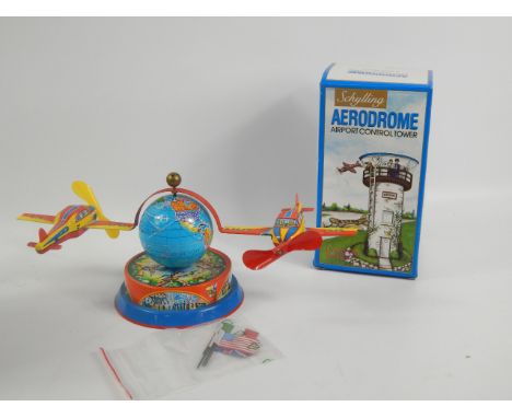 Two modern tin plate aviation related toys, an aerodrome airport control tower and two planes, mounted on a globe