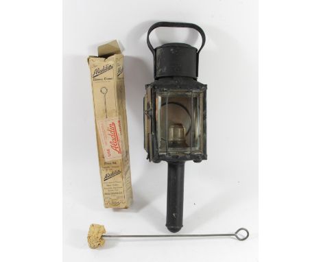 A candle burning coach lamp together with an original Aladdin lamp chimney cleaner, price marked 9D 