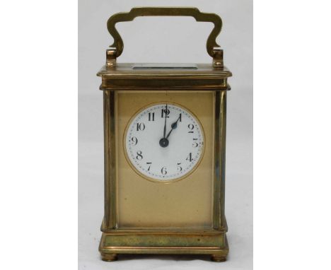 A 20th century brass carriage clock, the round enamel dial with Arabic numerals, impressed mark 'France' to back of movement,