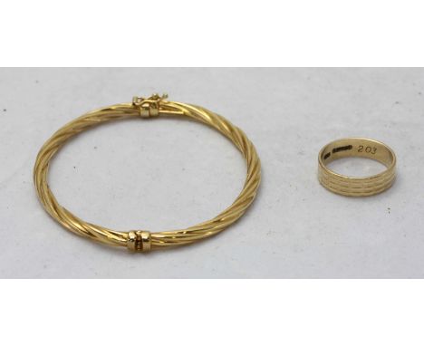 A 9ct gold twisted, stiff hinged bangle, together with a 9ct gold ring. Gross weight approximately 7.6g.