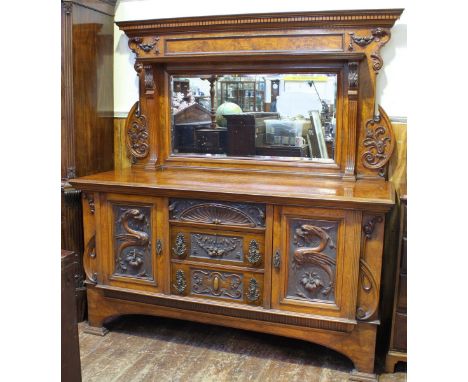 An Edwardian burr walnut and carved walnut sideboard, with raised mirrored back, fluted pilasters and shelf with applied carv