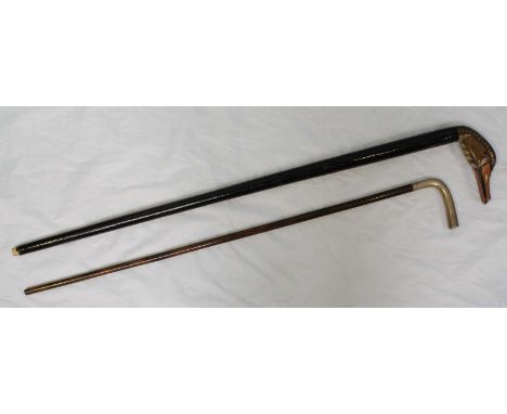 A silver handled, Macassar ebony walking stick, together with a modern cane, the handle carved and painted as a duck.