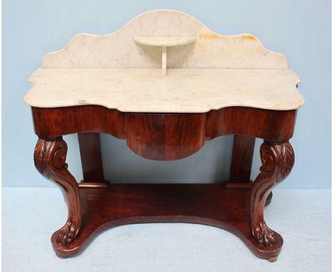 A Victorian mahogany washstand, the shaped marble top and back with shelf, above a single frieze drawer and raised on scrolle