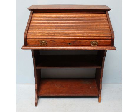 A 1920's stained oak bureau, the roll top opening to reveal pigeon holes, above an open storage shelf. 76cm wide.