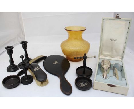 An ebonised dressing table set, some pieces with applied silver detailing and a boxed white metal brush and comb set, the bru