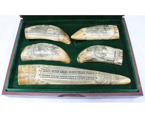 A set of five ornate resin scrimshaws, one fashioned as a cribbage board, all housed in a wooden box, with a fitted, green fe
