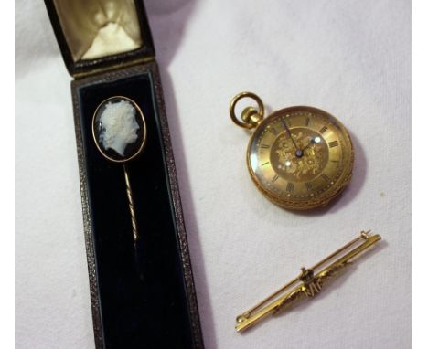 A hardstone cameo stick pin depicting a Romanesque figure head together with a yellow metal fob watch marked 18k with a gilt 