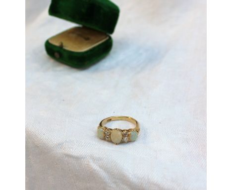 An opal and diamond half hoop ring, set with three oval opals and four old cut diamonds to a yellow metal mount and shank mar