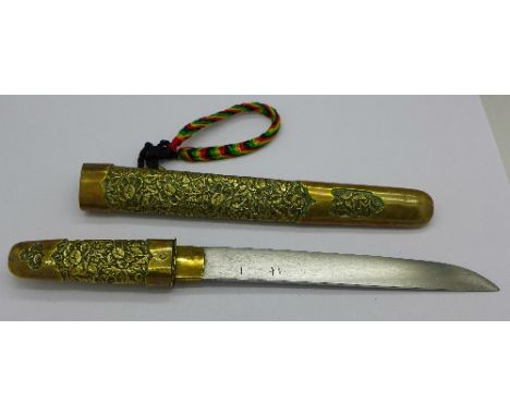 An oriental dagger with brass handle and scabbard