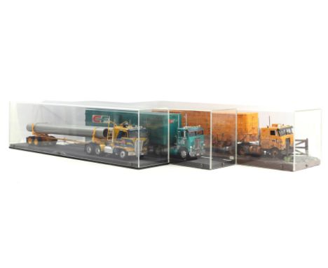 3 scale model trucks in plexiglass display cases, 2x 21 cm high, 81x16 and 1x 21 cm high, 81x21 cm
