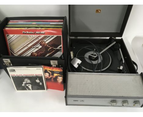 An HMV portable record player and a record case of LPs and 7" singles by various artists including The Beatles, Elvis Presley