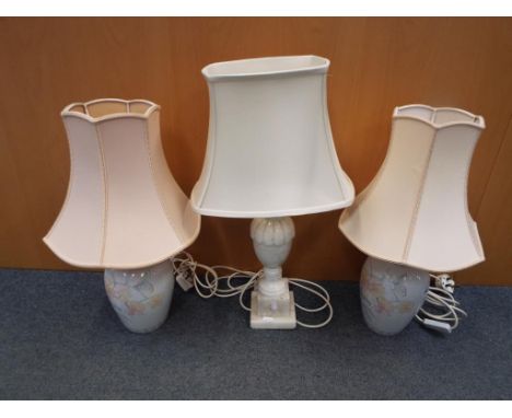 A pair of ceramic based table lamps decorated flowers and butterflies and a further table lamp with alabaster base, largest b