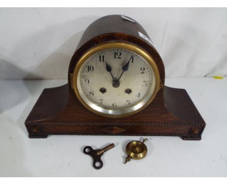 A good quality oak cased mantel clock with pendulum and key