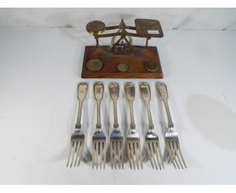 An miniature set of brass postal scales on a mahogany base with a small quantity of weights and six forks engraved to the han