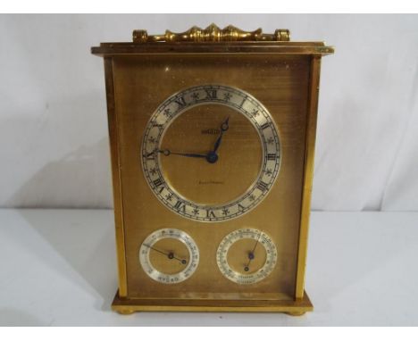 A brass cased combination clock with barometer and thermometer, Roman numerals to a silvered chapter ring, marked Angelus