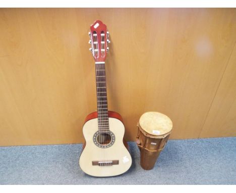 A beginner's acoustic guitar bearing paper label AVSLl-cord model No. CC12 and a wooden drum with animal skin, approximate he