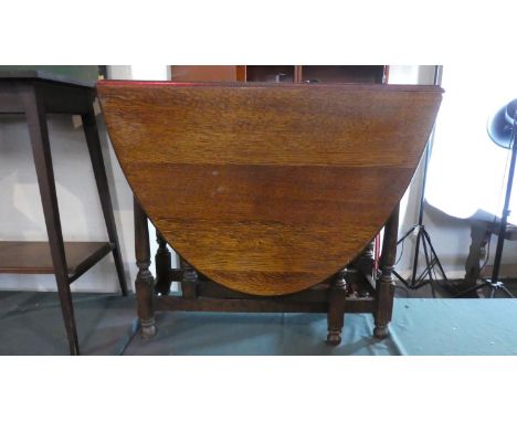 An Edwardian Oak Oval Topped Drop Leaf Gate Legged Dining Table. 87cm Wide 