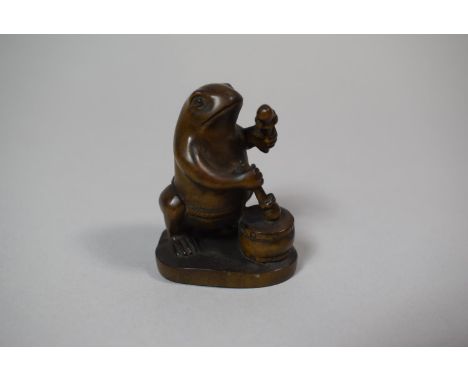 A Japanese Carved Wooden Netsuke in the form of a Frog Banging Taiko, 5.5cm High 