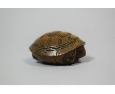 A Carved Wooden Netsuke in the form of a Tortoise, signed, 4.5cm wide x 2cm high 