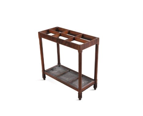 AN EDWARDIAN MAHOGANY STICK STAND, of rectangular form, the top divided into six sections, raised on chamfered supports termi