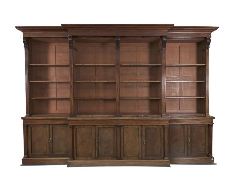 A LARGE GEORGE IV MAHOGANY BREAKFRONT BOOKCASE, with stepped moulded cornice above open shelving, interposed with reeded corb