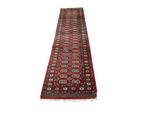 A Bokhara red ground runner and smaller rug, larger 300 x 78cm