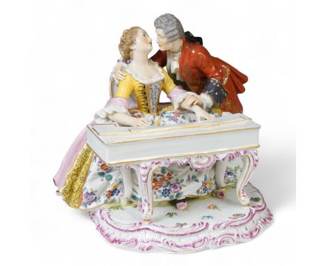 A large German porcelain group lovers at a piano, 22cm high,