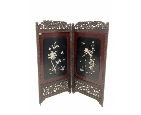 Early 20th century Japanese bi-fold privacy screen, with profusely carved hardwood frame enclosing lacquer panels decorated w