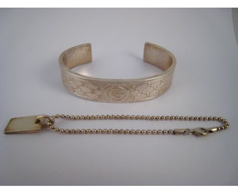 A white metal (tests silver) bangle, marked Gucci 925, together with an ID bracelet, gross weight 50.9 gms.
