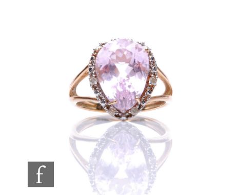 A 9ct hallmarked kunzite and diamond cluster ring, pear shaped claw set kunzite within a diamond set border, all to split sho